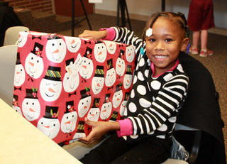 Girl at Theodora House receiving a Christmas gift