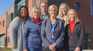 Kathy and the rest of the senior team in front of a VOA Utah building